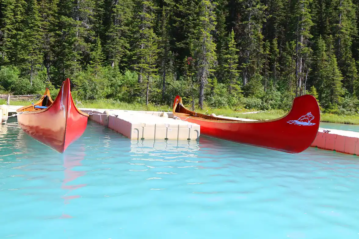 two red canoes sitting at the dock on the water