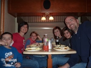 Family sitting at table in RV for family dinner