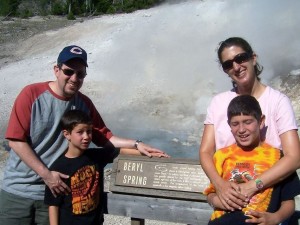 Family standing infront of Beryl Spring in Yellowstone National Park