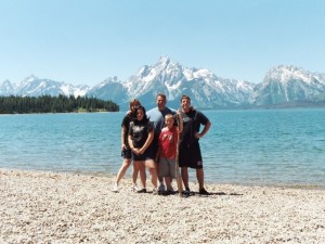 Family posing in front of Jackson Lake and the Grand Tetons