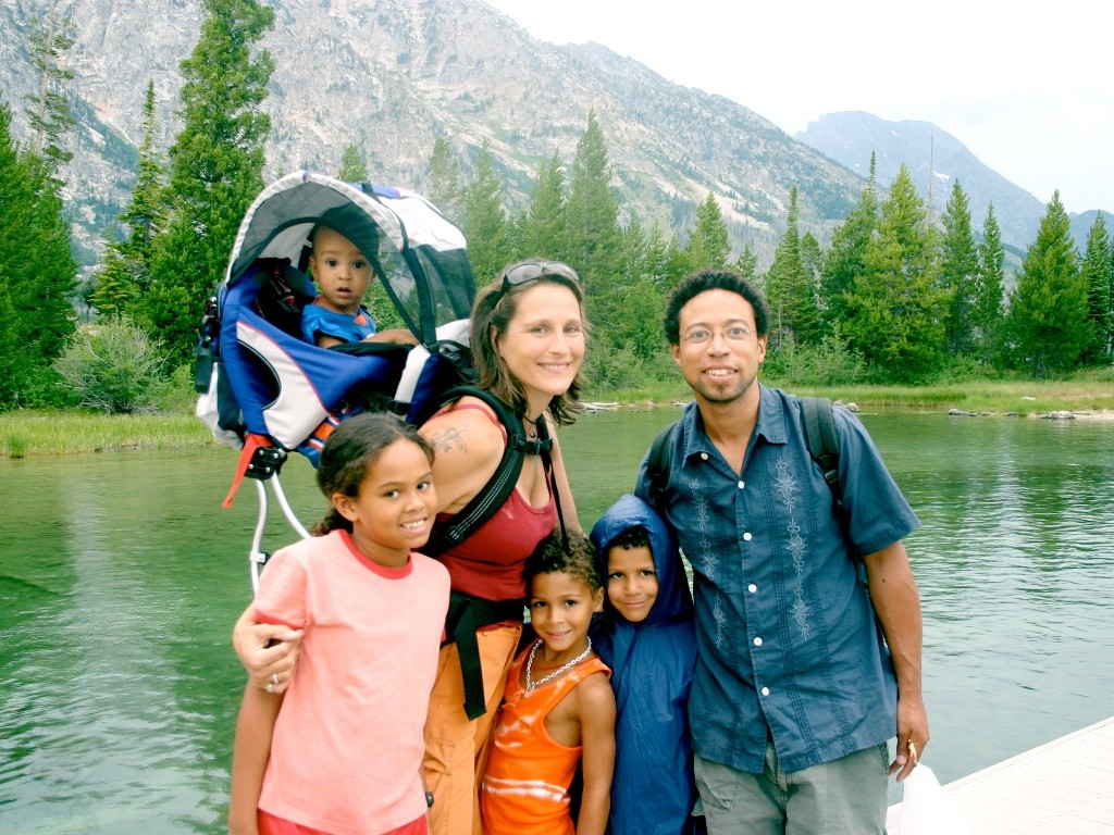 Family on a hike posing infront of a lake in Grand Teton National Park