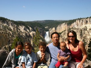 Family posing in front of the waterfalls near Canyon in Yellowstone National Park