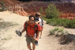 Father giving his son a piggyback ride in front of the amphitheater in Bryce Canyon