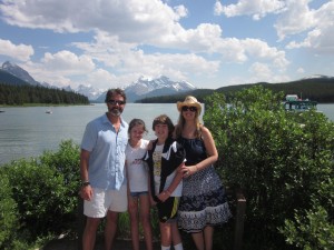 Family posed in front of scenic lake
