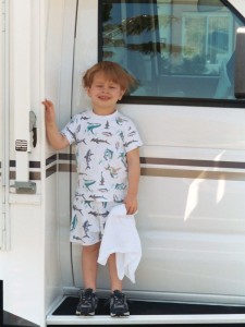 Little boy in pajamas in front of the family rental RV