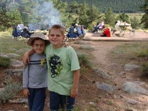 Two small boys embracing in front of a campfire