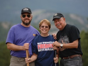 Three adults hiking and holding hiking poles