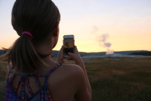 woman taking photo with cell phone of national park