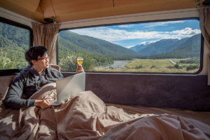 man relaxing inside RV with a mountain view