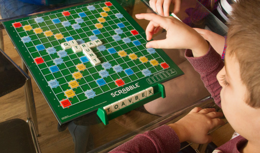 young boy playing scrabble